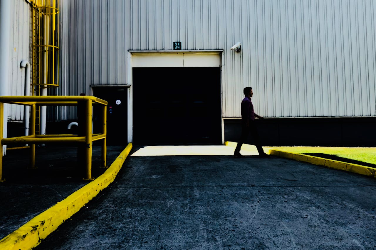 services-02 Person walking past a large industrial garage door in a daytime setting.